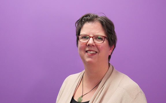 Photograph of Liv Jonassen with a purple background.